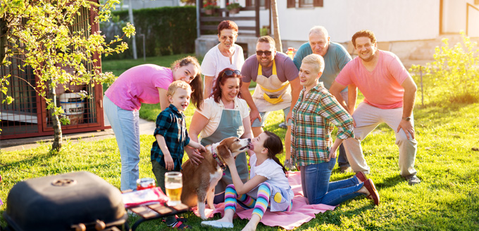 family barbecuing with their dog