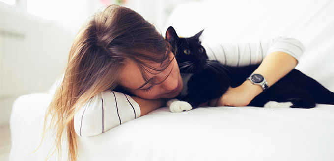 Girl with cat lying on the bed