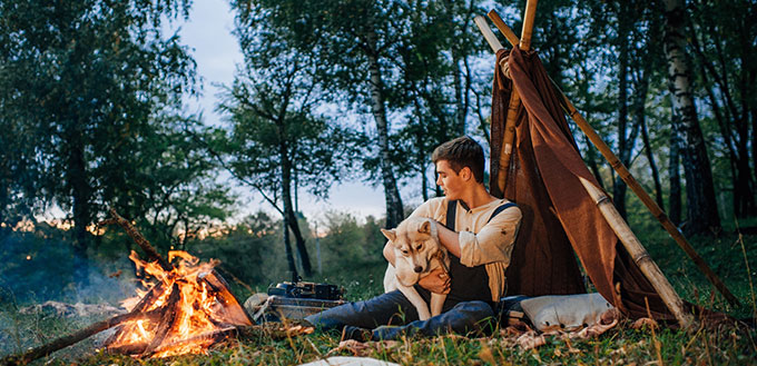 Guy sitting around a campfire