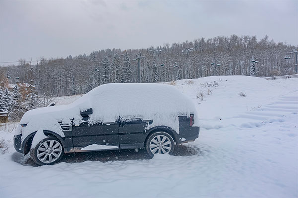 SUV car Buried in snow during winter snowstorms on Ski lift background