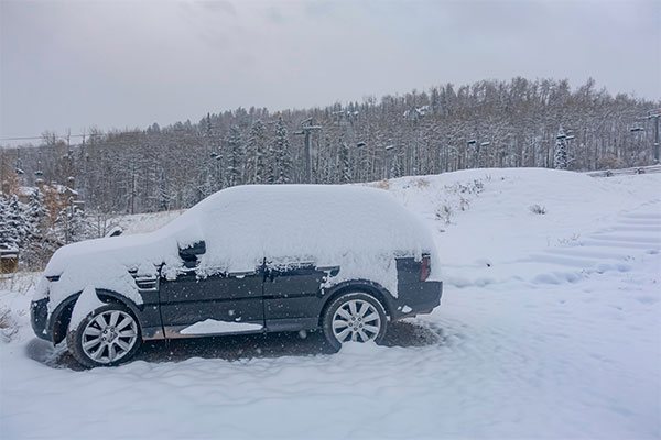 Voiture SUV enterré dans la neige pendant les tempêtes de neige d'hiver sur fond de remontées mécaniques