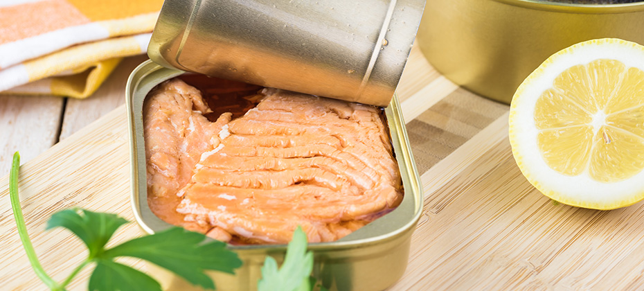 Open canned fish. Tin can with smoked salmon fillets.