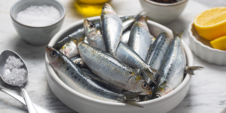 Fresh sardines, lemon and salt on kitchen, close up shot