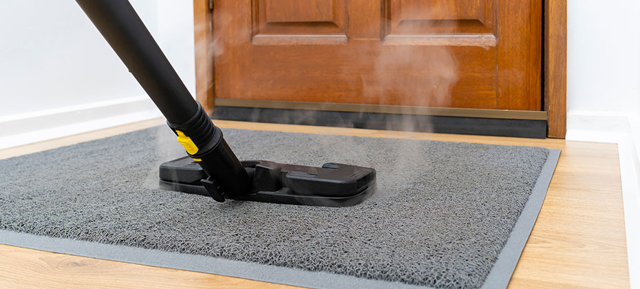 sanitizing front doormat using steam cleaner