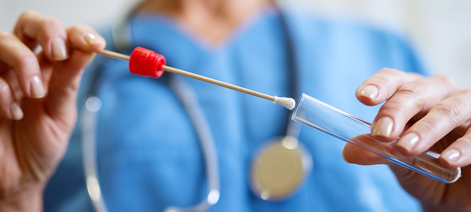 Close up of nurses hands holding buccal cotton swab and test tube ready to collect DNA from the cells