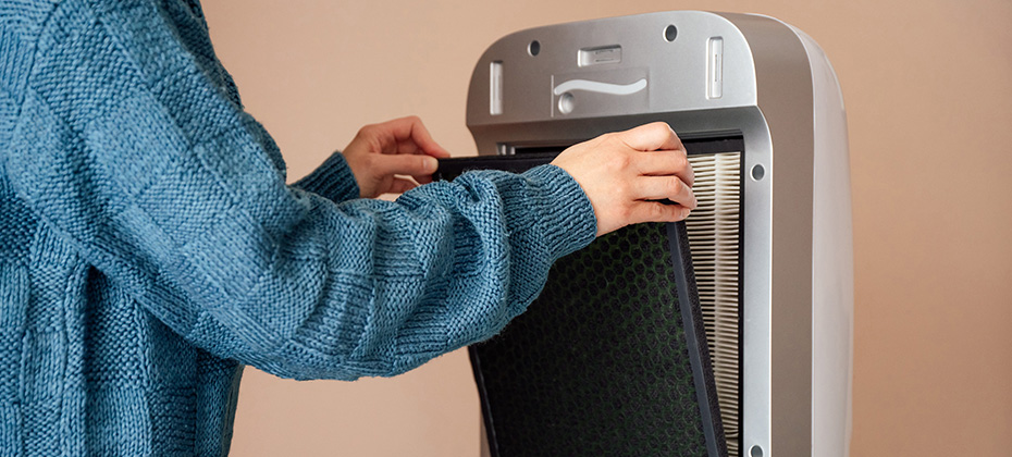 Hands changing air, dust, carbon and hepa purifier filters