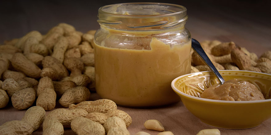 Peanuts and peanut butter in a jar on the table