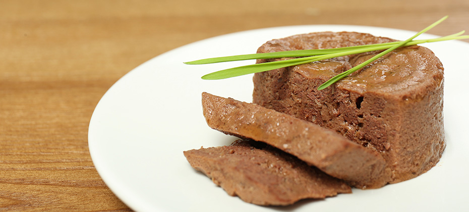 Plate with pate and grass on wooden table closeup Pet food